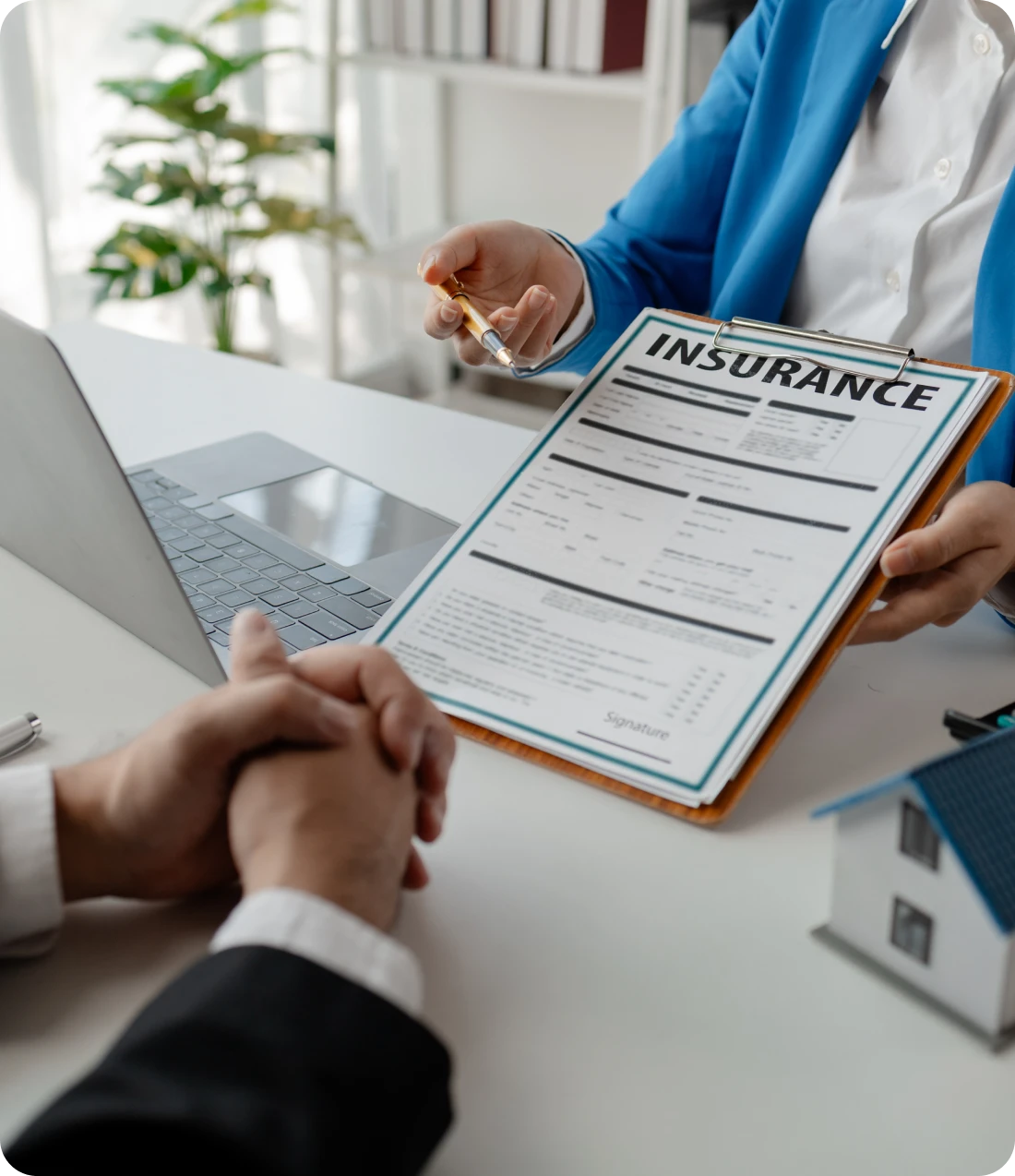 Person explaining and asking another person to sign insurance policy documents