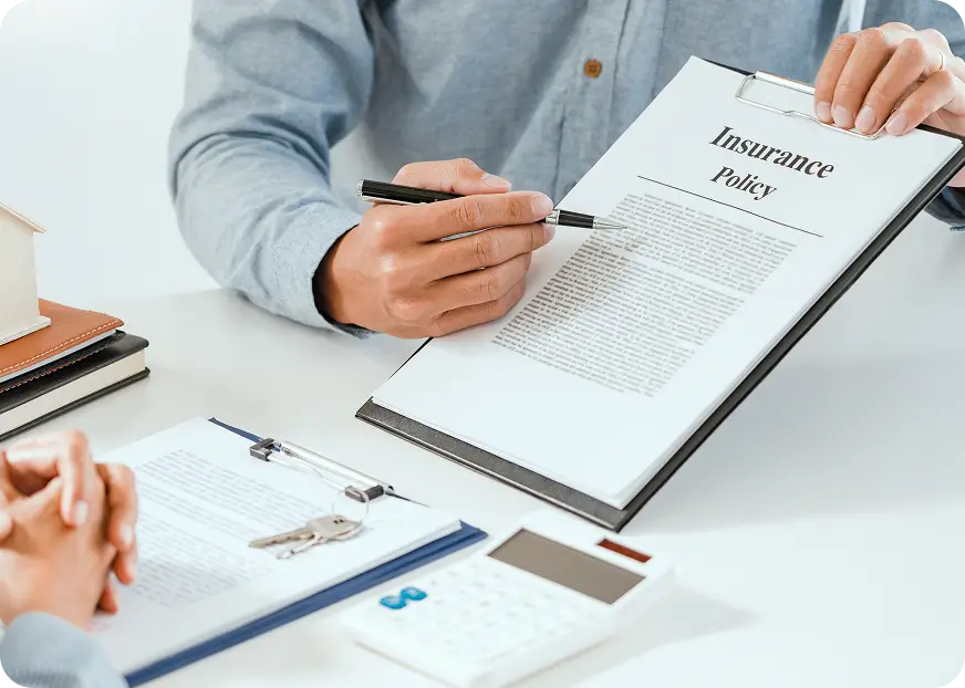 Insurance policy document on a clipboard being reviewed and explained at a desk, highlighting key terms and coverage details