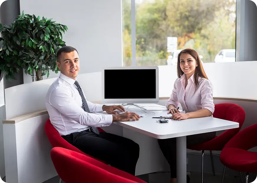 Insurance consultation between two professionals reviewing forms at a desk in a modern office